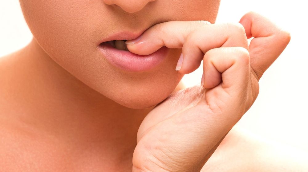 close female mouth biting her fingers | Nail Biting | Everything You Need To Know