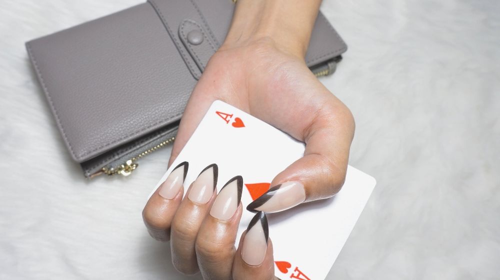 black tip french manicure holding playing card | Long Fingernails Hacks For People Having A Hard Time Doing Chores
