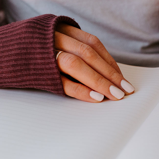 person writing on white paper | Lizzo's Trendy Milky White Nails We Absolutely Love