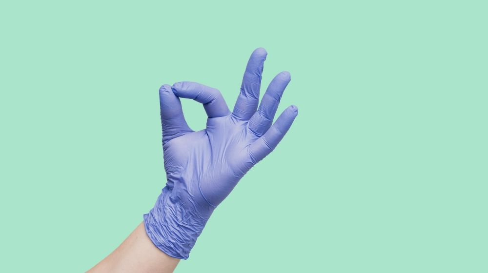 hand glove isolated over mint color | Long Fingernails Hacks For People Having A Hard Time Doing Chores