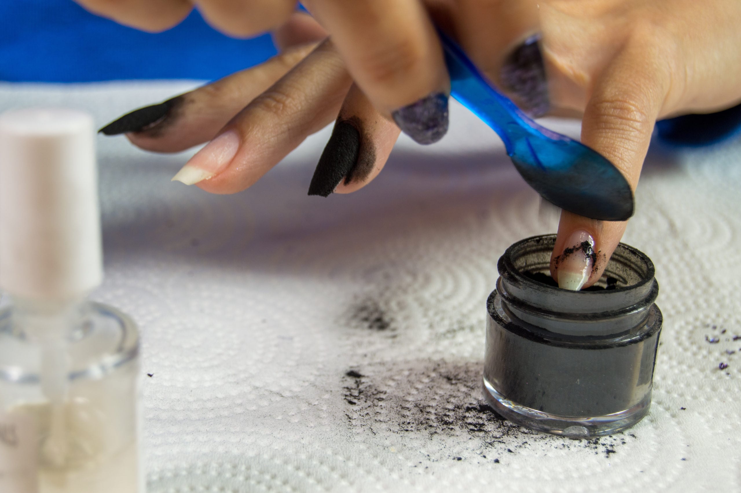 woman spooning dip powder on base | Facts About Dip Powder Nails You Need Know